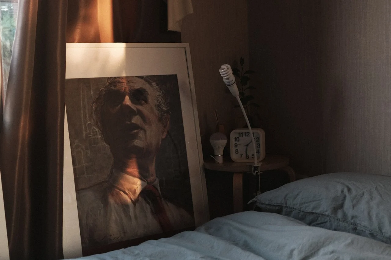 Zarámovaná fotografia pri posteli na nočnom stolíku
