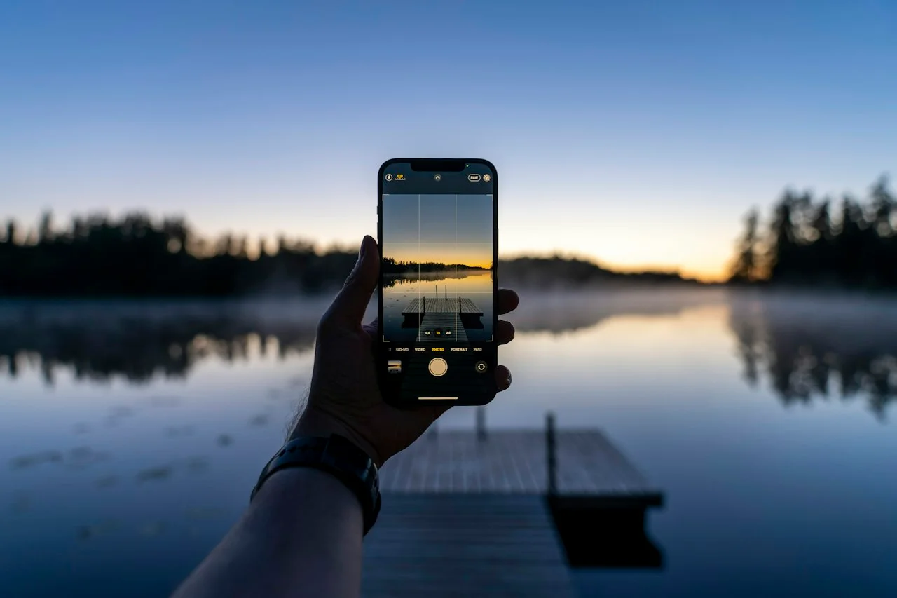 Mobil s mriežkou v aplikácii fotoaparátu pred jazerom za súmraku