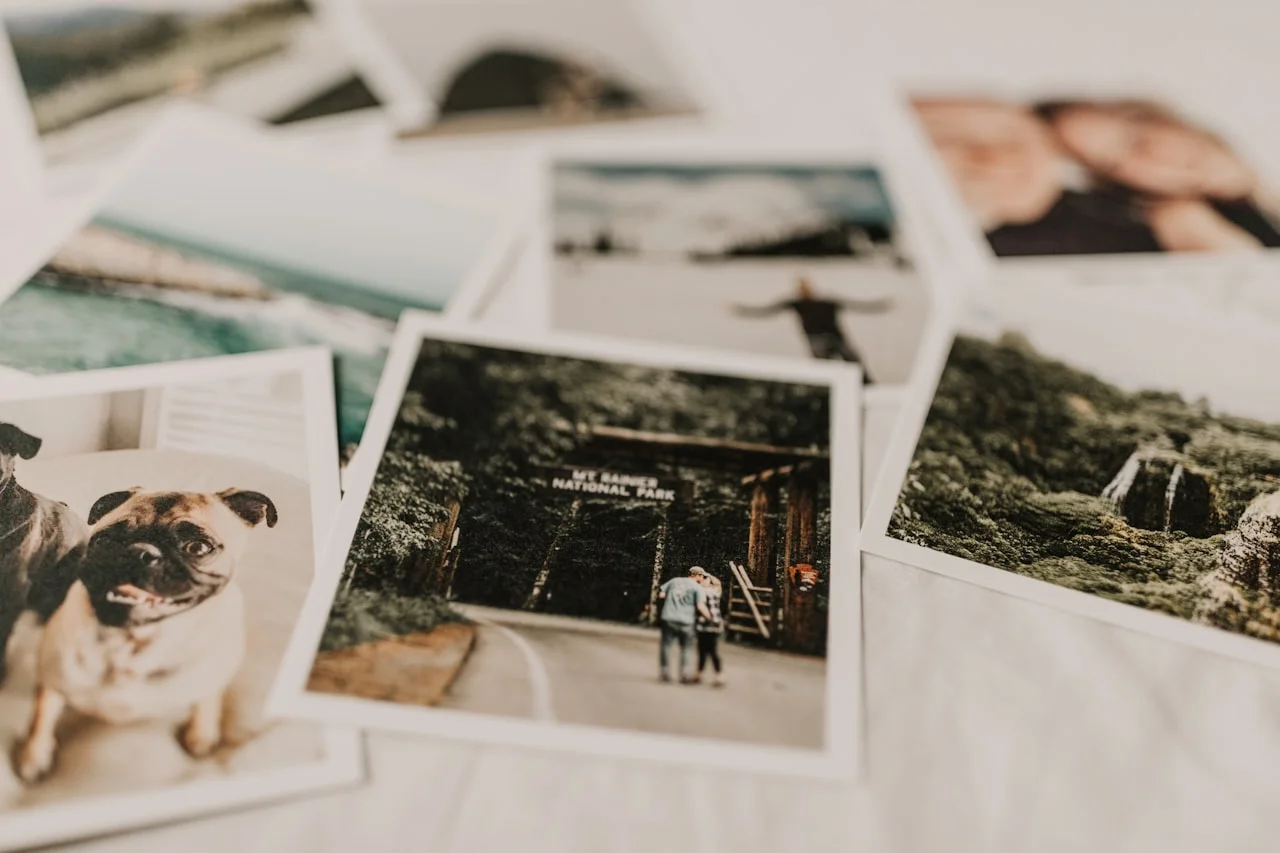 Vytlačené fotografie s bielym okrajom rozložené na svetlom podklade