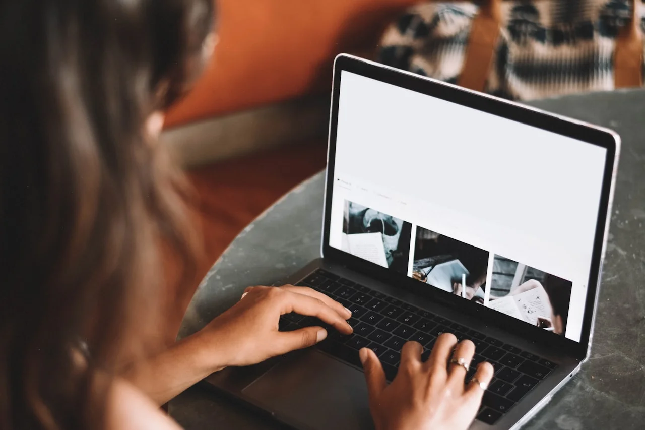 Osoba prezerá fotografie na notebooku pri dennom svetle