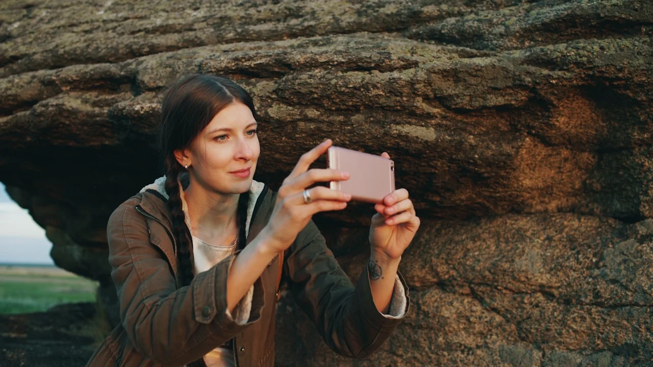 Žena fotí telefónom skalnatú krajinu