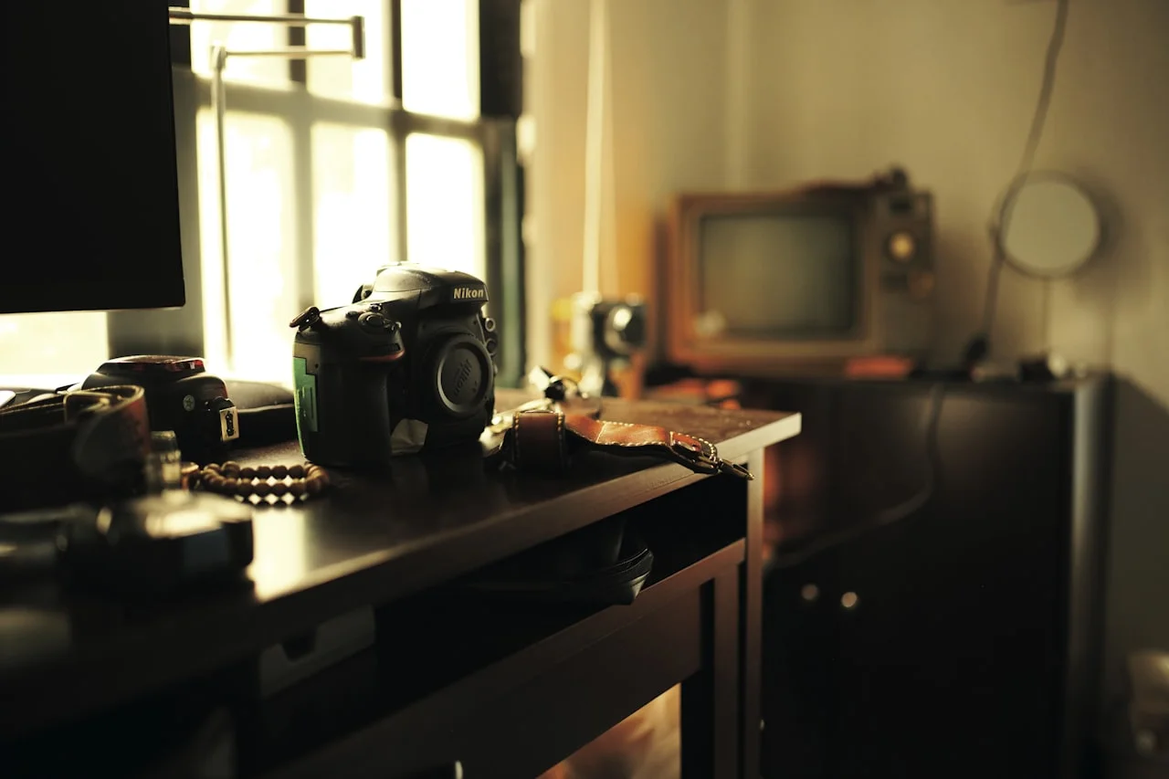Starý fotoaparát a tlačené fotografie na pracovnom stole